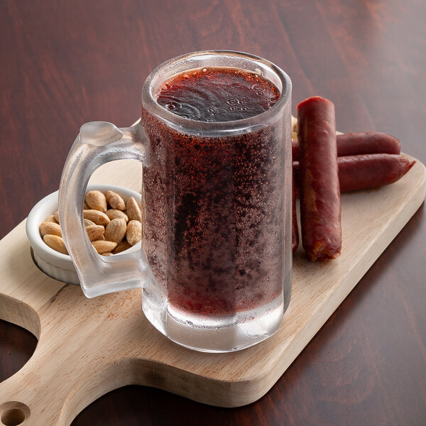 A glass mug with Boylan Creamy Red Birch Beer and nuts on a cutting board.