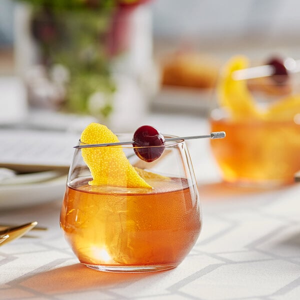 An Acopa rocks glass with a drink and orange and cherry garnish.