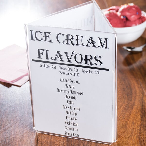A Tablecraft clear acrylic three sided menu table tent displaying a menu on a table.