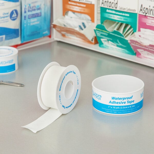 A white roll of Medi-First adhesive tape on a counter.