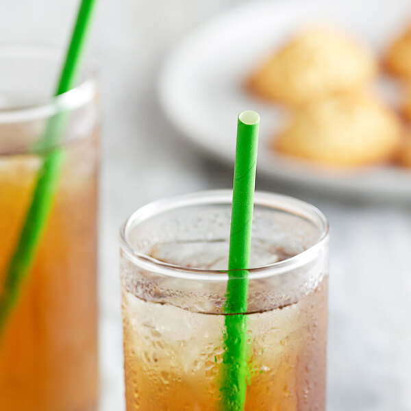 A glass of iced tea with a green EcoChoice jumbo straw in it.