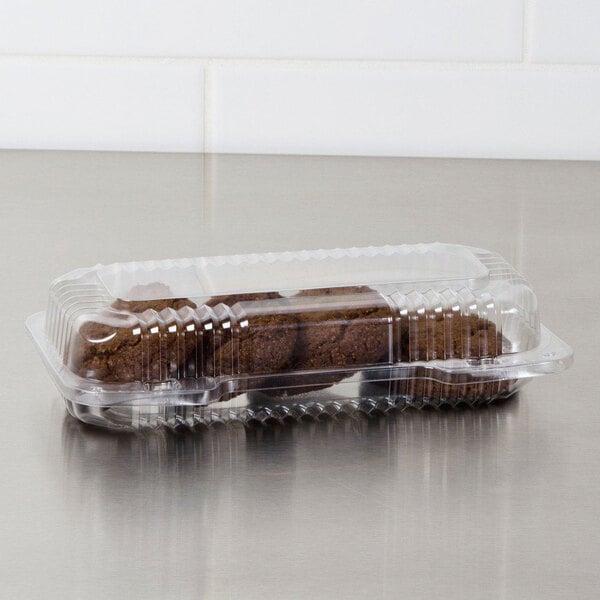 A Dart clear hinged plastic container with brown cookies inside.