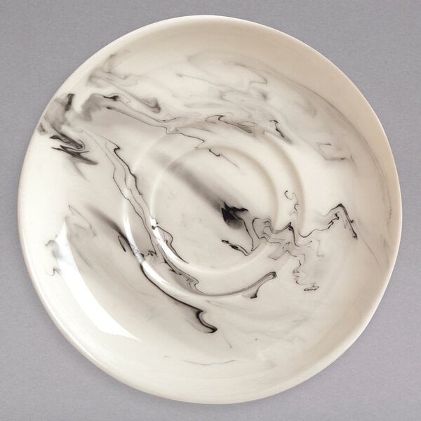 A white porcelain saucer with a black swirl design.