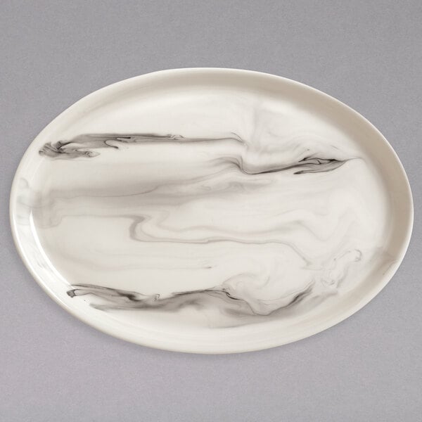A white oval porcelain platter with a black and white marble pattern.