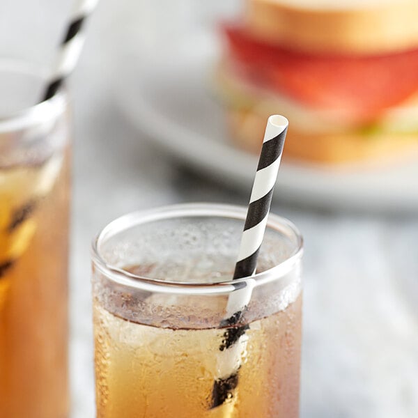 Two glasses of iced tea with black and white striped EcoChoice paper straws on a table.