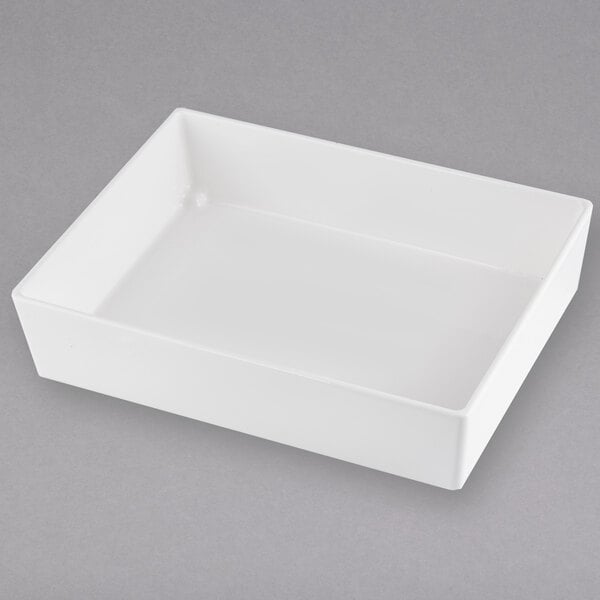 A white rectangular Tablecraft bowl on a gray surface.