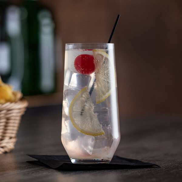 A Stolzle longdrink glass filled with lemonade, lemons, and a cherry.