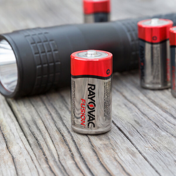 A group of Rayovac Fusion C batteries next to a flashlight.