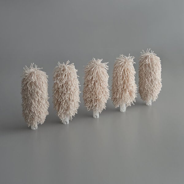 A group of five white Noble Products brush heads.