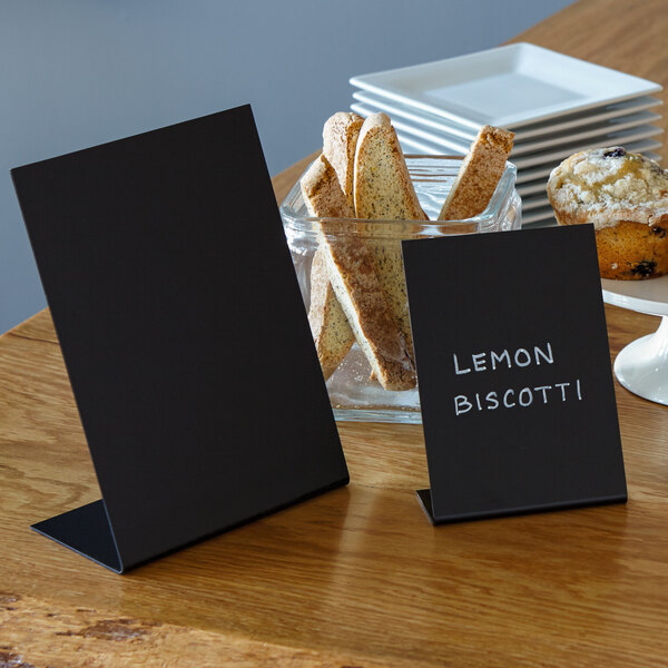 A black American Metalcraft tabletop chalkboard sign with white text reading "Lemon Scone" on a table with a plate of cookies.