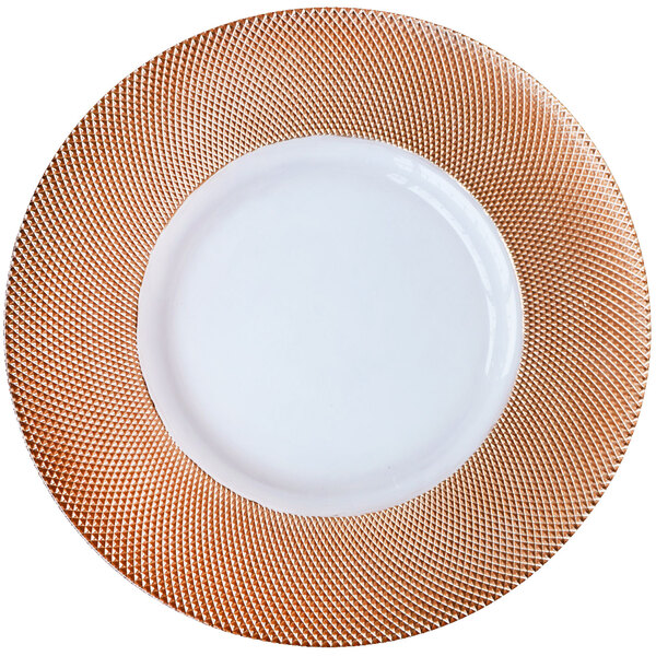 A white plate with a rose gold diamond rim on a woven mat.