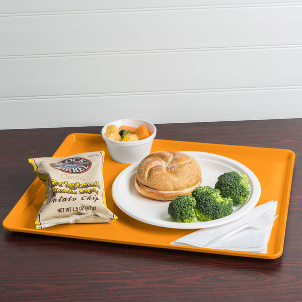 A mustard Cambro dietary tray with a sandwich, broccoli, and a drink.