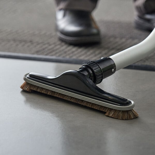 A person using a Lavex floor brush to clean the floor.