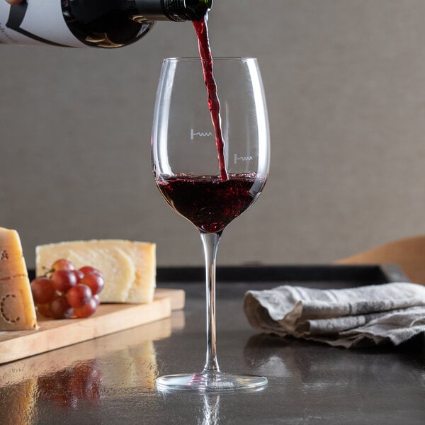 A Reserve by Libbey Acura Renaissance wine glass being used to pour red wine.
