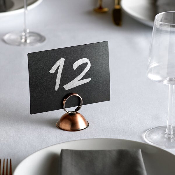 An antique bronze table card holder with a number 12 on it.