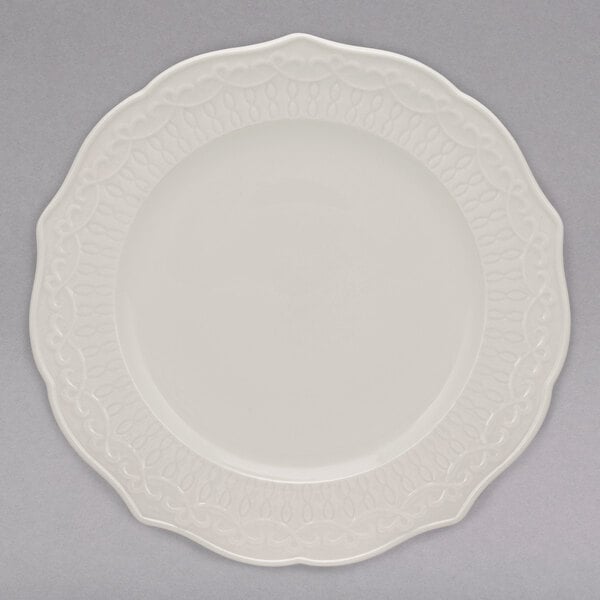 A 10 Strawberry Street Ever white porcelain plate with a scalloped edge.