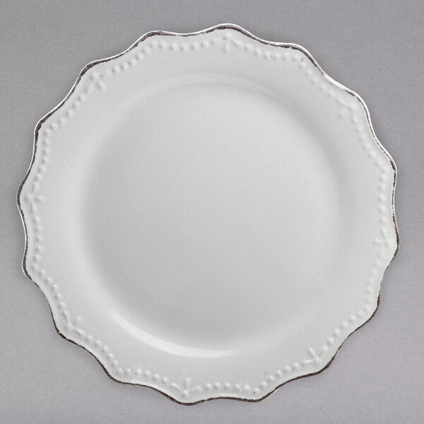 A white stoneware plate with silver trim.