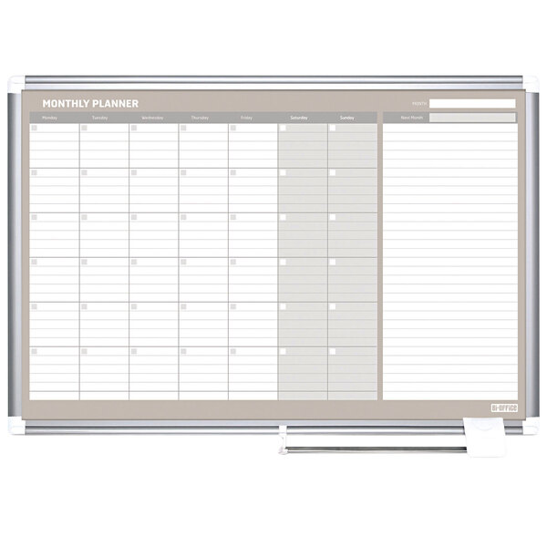 A white MasterVision monthly calendar on a white board with a silver aluminum frame.