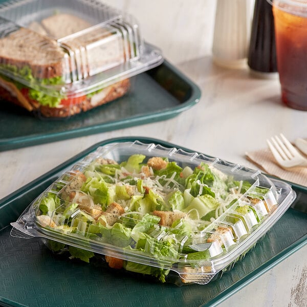 Clear plastic containers with salad in them on a table.
