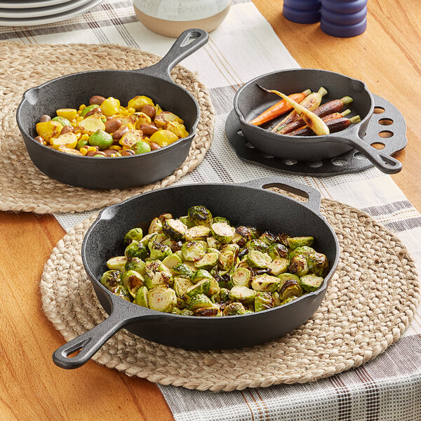 A Valor cast iron skillet set with carrots and other vegetables cooking.