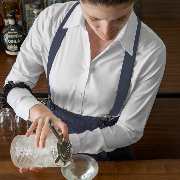 A woman using a Henry Segal dark grey elastic clip-end suspenders tool to make a drink.