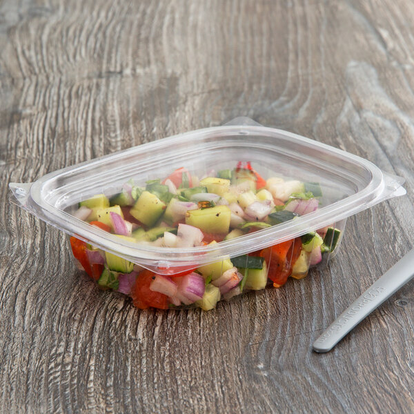 A rectangular Eco-Products deli container filled with salad on a wood surface.