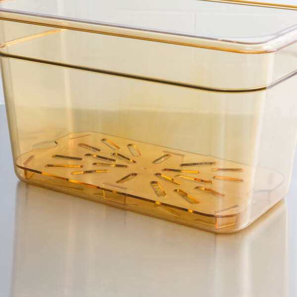 A transparent plastic tray with yellow liquid and holes in it.