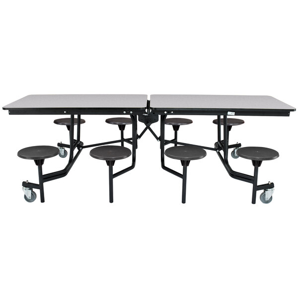 A rectangular black table with a black metal frame and T-molding edge with eight black round seats on a metal frame.
