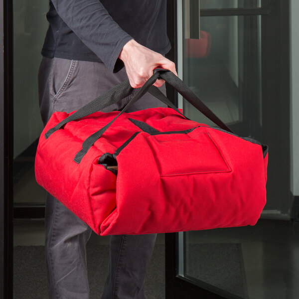 A man carrying a red Cambro Insulated Pizza Delivery GoBag.