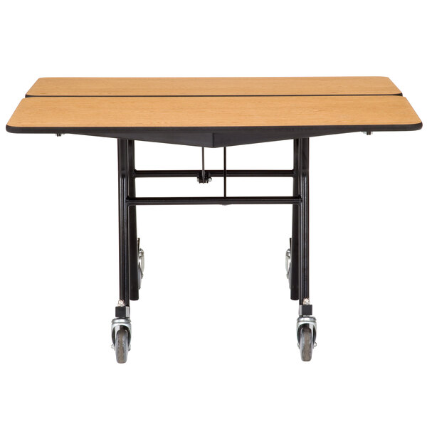 A National Public Seating square cafeteria table with wheels on it.