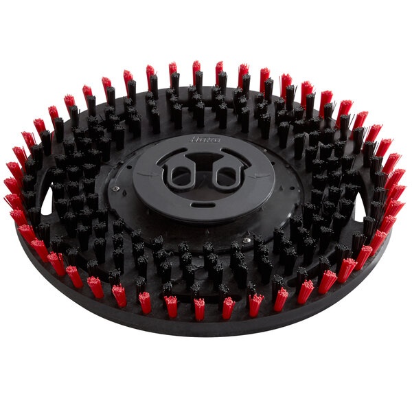 A circular black and red Minuteman pad driver with red bristles.