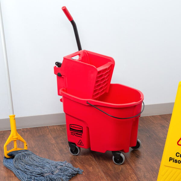 A Rubbermaid red mop bucket on a wood floor.