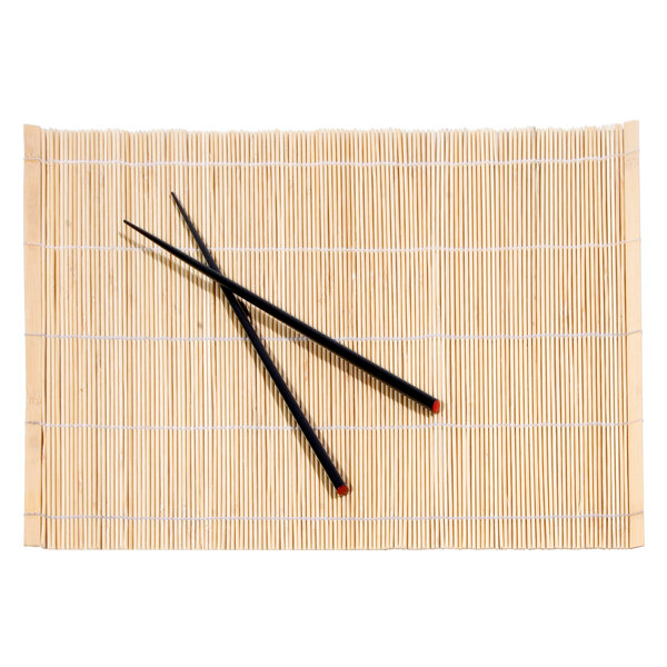 A pair of chopsticks on a natural bamboo mat.