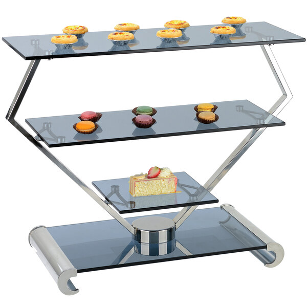 A Bon Chef stainless steel and glass display stand with three tiers of cupcakes.