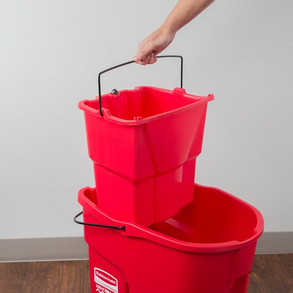 A red Rubbermaid WaveBrake dirty water bucket with a handle.