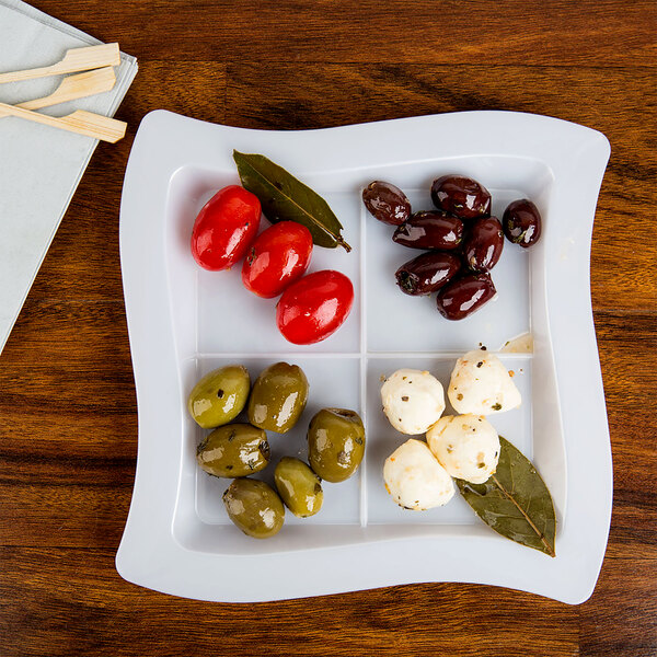 A white Fineline disposable plastic tray with olives and cheese.