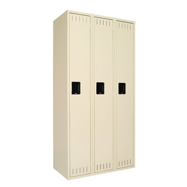 A sand-colored Tennsco steel locker with three doors and black rectangular handles.