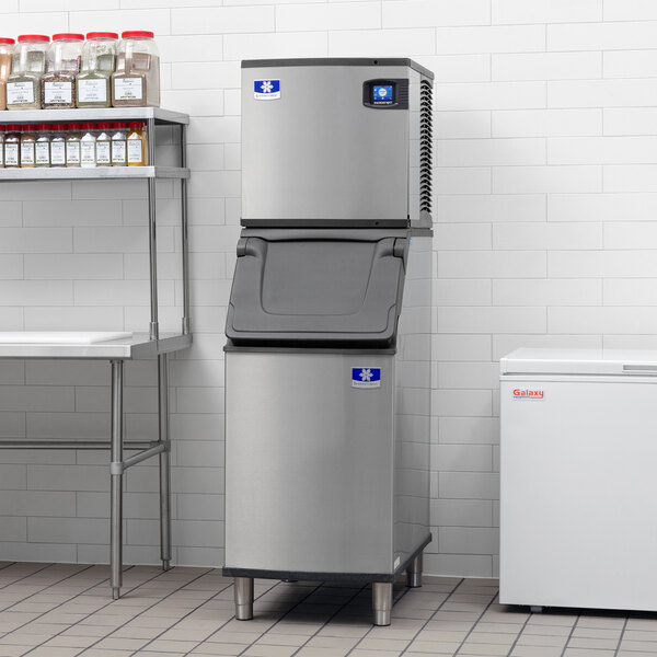 A Manitowoc air cooled ice machine with bin in a kitchen.