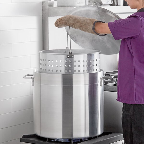 A woman in a purple coat cooking in a Choice aluminum stock pot.