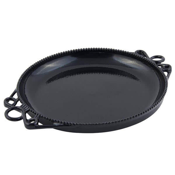 A black round Bon Chef cast aluminum platter with handles and a decorative design.