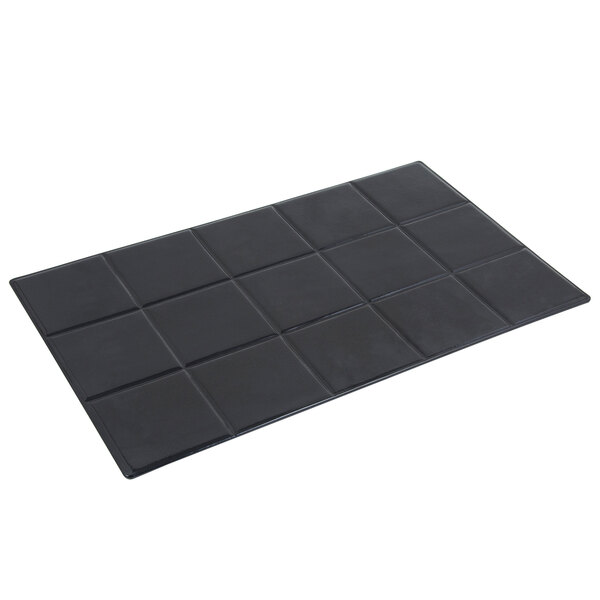 A black rectangular tile with squares on a white surface.