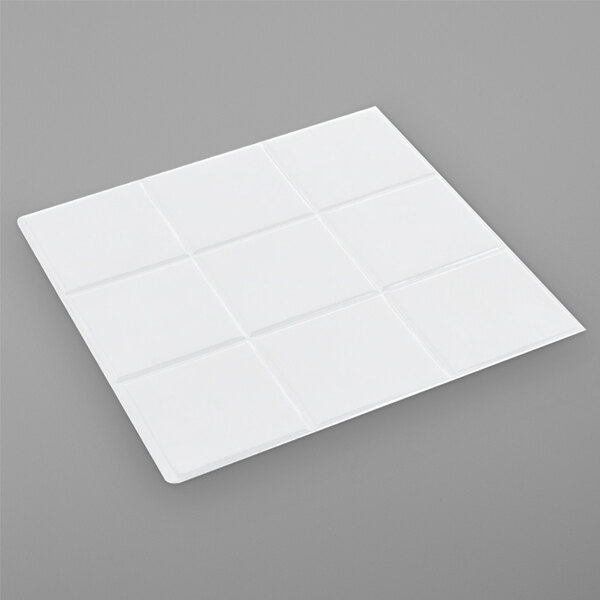 A white square Bon Chef tile on a gray surface.