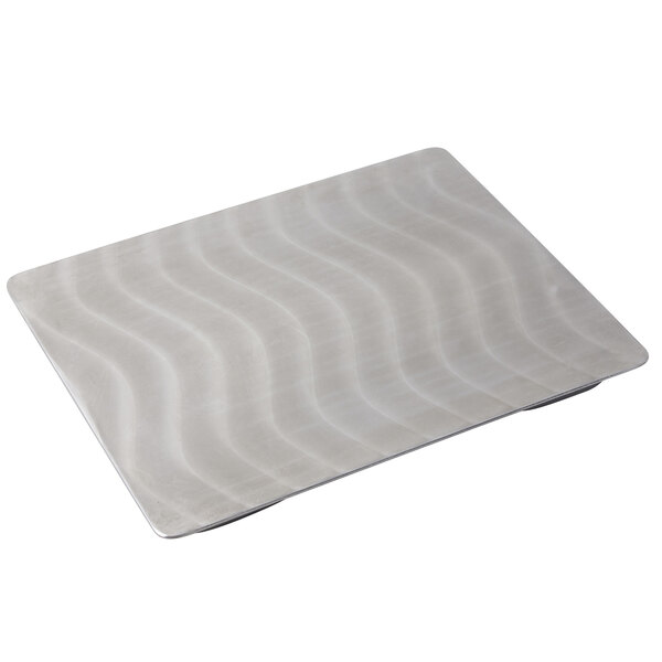 A stainless steel rectangular tile with wavy lines on it.