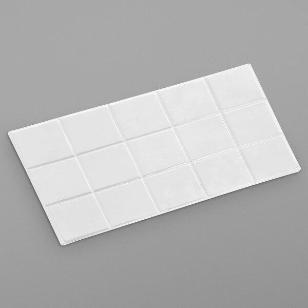 A white rectangular tile with a square pattern.