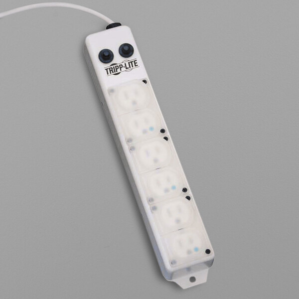 A white Tripp Lite medical-grade power strip with black safety covers over six outlets.