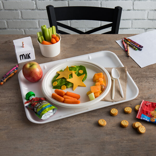 A white CKF foam school tray with food on it, including star-shaped vegetables.