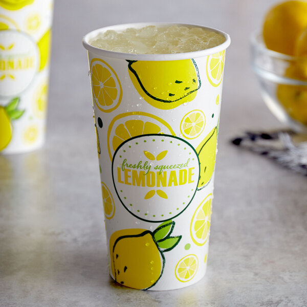 A close up of a white paper cup with lemons on it.