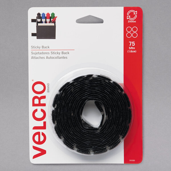 A roll of black Velcro sticky back dots with white backing.
