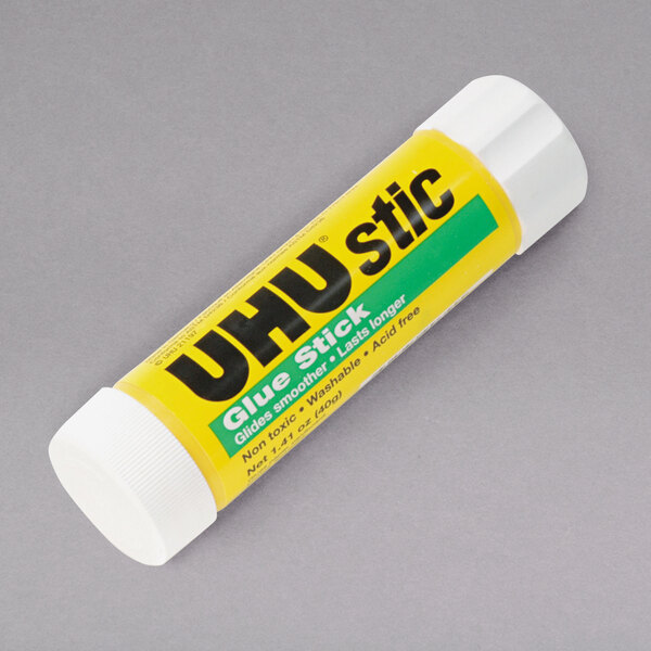 A close-up of a yellow UHU glue stick tube with black text.