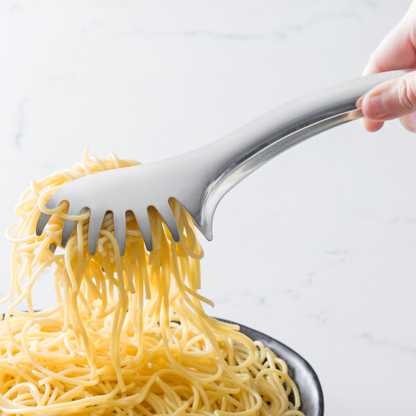 A hand uses Vollrath stainless steel pasta tongs to serve spaghetti on a fork.